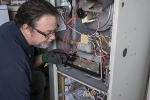 technician looking at a gas furnace