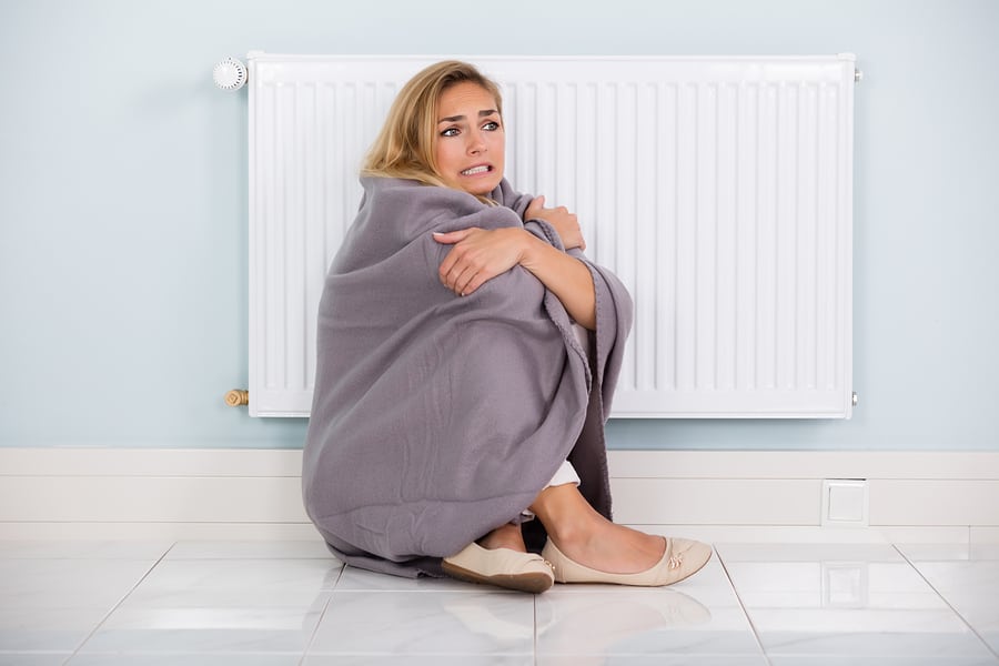 woman sitting on the floor wrapped in a blanket